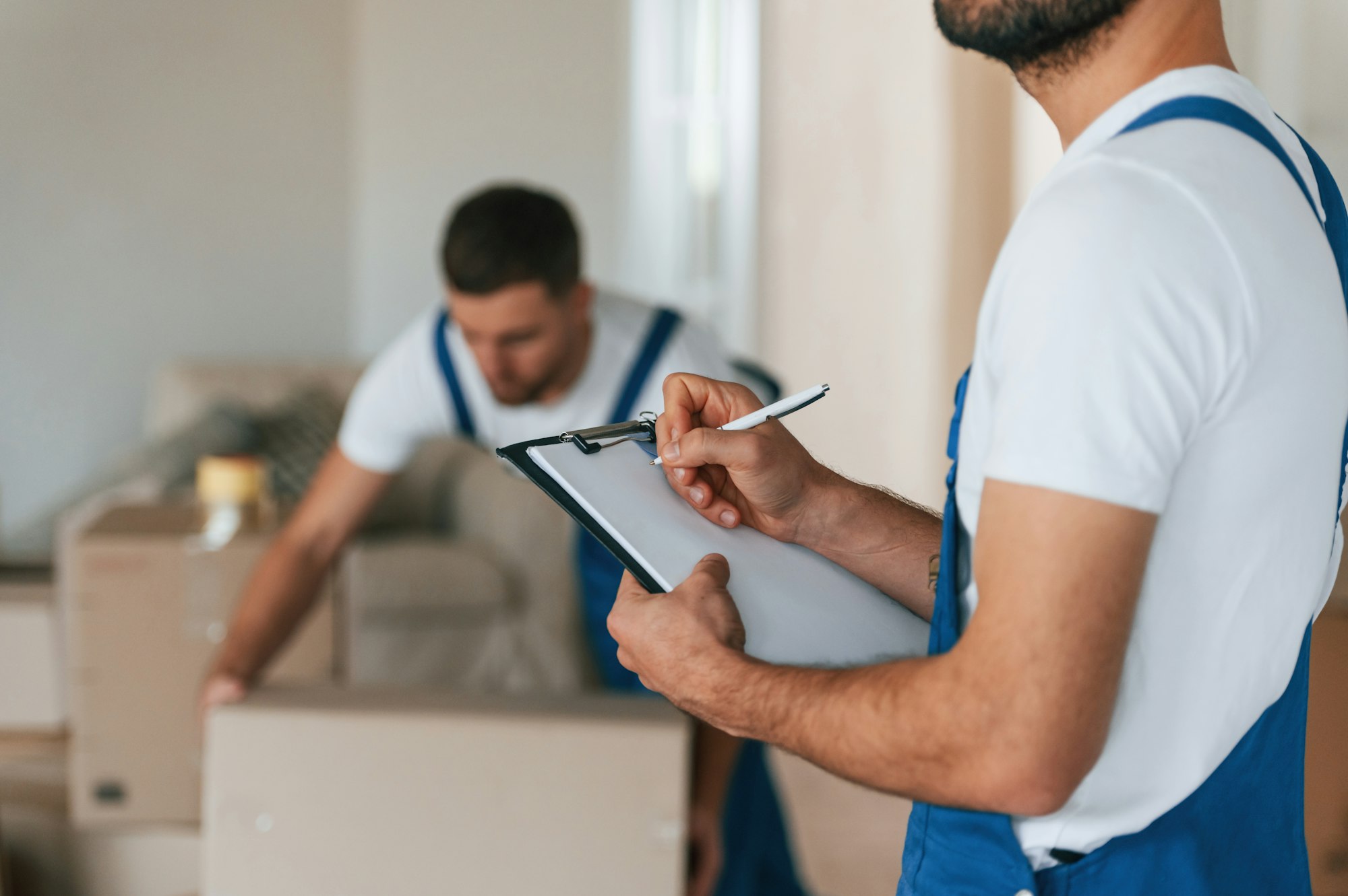 two moving service employees in a room